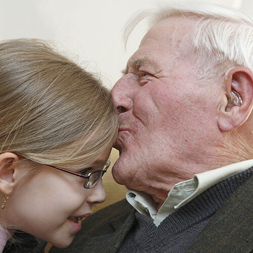 grandfather kissing his toddler granddaughter